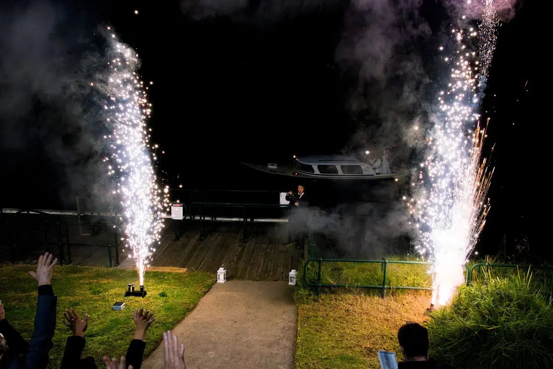 Two fountains of white sparks on a lawn at night